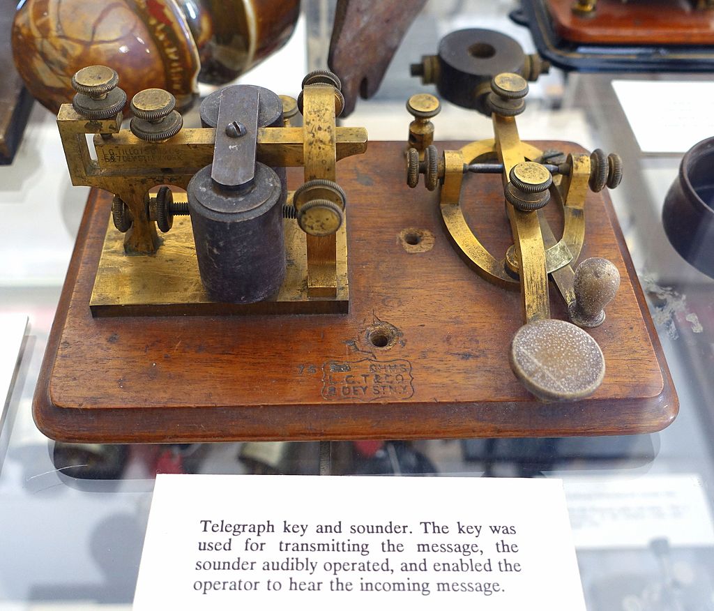 A vintage Morse telegraph key on a wooden base.
